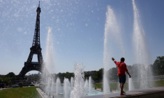 Un touriste se rafraîchit dans la fontaine du Trocadéro à côté de la Tour Eiffel alors qu'une vague de chaleur précoce frappe Paris