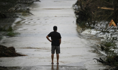 Un homme sur une route dévastée par les inondations à Hunt, au Texas, le 6 juillet 2025 ( AFP / RONALDO SCHEMIDT )