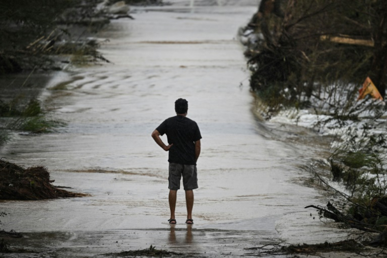 Un homme sur une route dévastée par les inondations à Hunt, au Texas, le 6 juillet 2025 ( AFP / RONALDO SCHEMIDT )