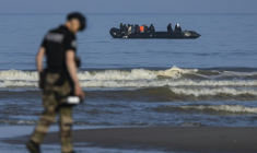 Un gendarme sur la plage d'Equihen (Pas-de-Calais), devant une embarcation transportant des migrants, le 30 juin 2025 ( AFP / Sameer Al-DOUMY )