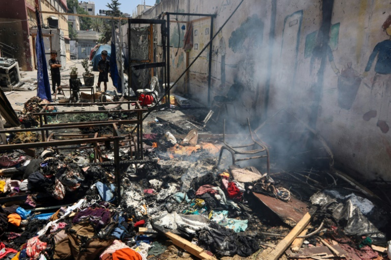 Des enfants regardent les débris encore fumants de l'école Mustafa Hafez, à Gaza-ville, le 3 juillet 2025 ( AFP / Omar AL-QATTAA )
