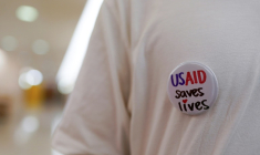 Un ancien employé fédéral porte un badge "USAID sauve des vies", lors d'un sit-in le 24 juin 2025 à Washington ( GETTY IMAGES NORTH AMERICA / Jemal Countess )