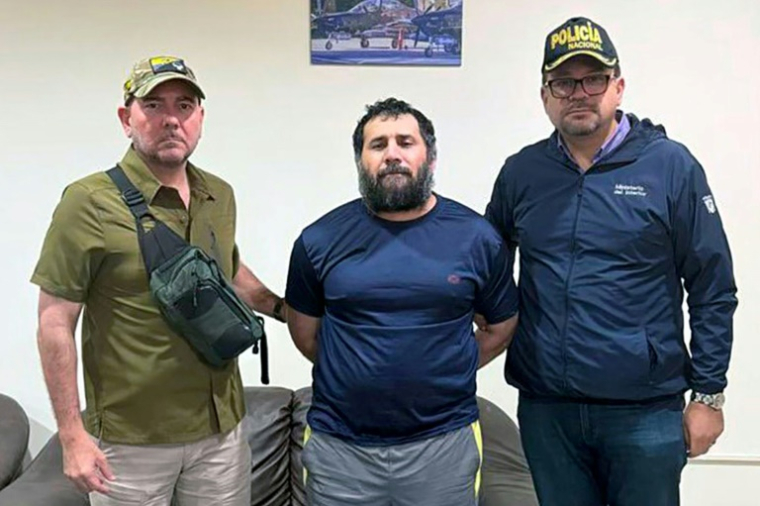 Photo diffusée par l'armée équatorienne du narcotrafiquant Adolfo Macias, alias "Fito" (c), entouré par le ministre de la Défense Carlo Loffredo (g) et le ministre de l'Intérieur John Reimberg, après sa recapture, le 25 juin 2025 à Manta, en Equateur  ( Armée équatorienne / Handout )