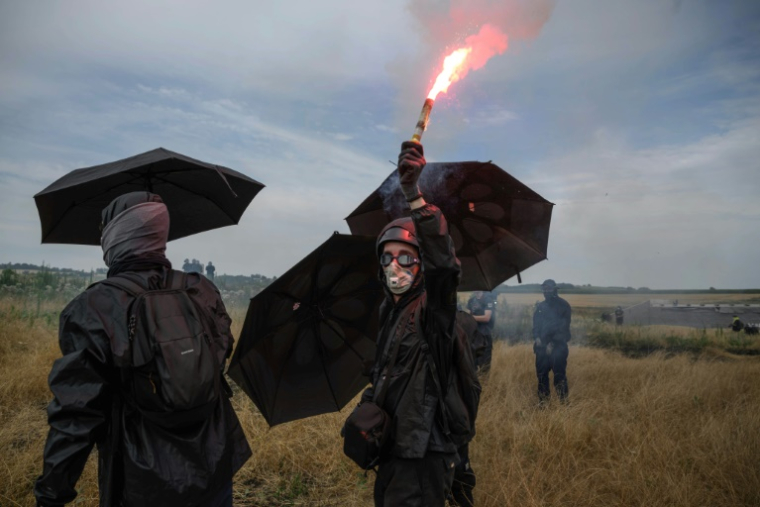 Un manifestant tient une fusée éclairante lors d'un rassemblement contre le projet d'autoroute A69, à Morens-Scopont, dans le sud de la France, le 5 juillet 2025 ( AFP / Ed JONES )