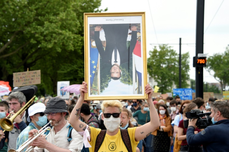 Un manifestant tient un portrait d'Emmanuel Macron lors d'une "Marche pour le climat", le 9 mai 2021 à Nantes ( AFP / Sebastien SALOM-GOMIS )