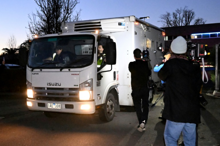 Des membres des médias suivent un véhicule de police transportant l'Australienne Erin Patterson alors qu'il quitte le tribunal de Latrobe Valley, le 7 juillet 2025 à Morwell ( AFP / WILLIAM WEST )