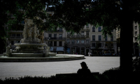 Une personne est assise à l'ombre sur la place des Jacobins, le 25 juin 2025 à Lyon ( AFP / JEFF PACHOUD )