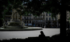 Une personne est assise à l'ombre sur la place des Jacobins, le 25 juin 2025 à Lyon ( AFP / JEFF PACHOUD )
