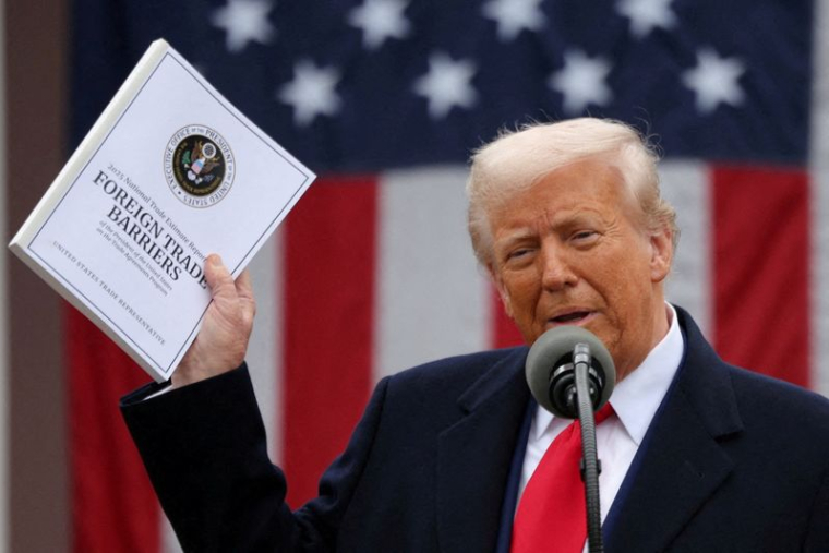 Le président américain Donald Trump tient un document "Barrières au commerce extérieur" alors qu'il s'exprime sur les tarifs douaniers dans la roseraie de la Maison Blanche à Washington