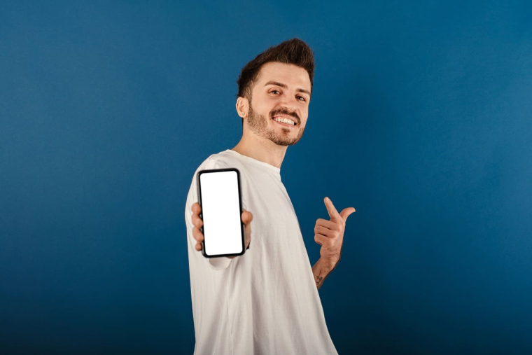 (Crédits photo : Adobe Stock - Jeune homme ravi d'avoir rejoint la banque la moins chère et qui fait deviner le montant de ses économies)