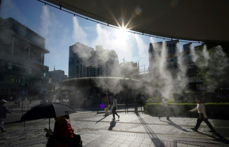 Une brume d'eau rafraîchissante dans une rue de Tokyo par une chaude journée, le 19 juin 2025 au Jaon ( AFP / Kazuhiro NOGI )