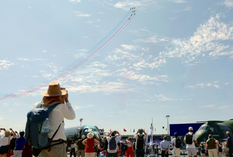 Des visiteurs regardent des avions de la patrouille de France pendant la 55e édition du Salon international de l'aéronautique et de l'espace à l'aéroport du Bourget, au nord de Paris, le 20 juin 2025 ( AFP / Thomas SAMSON )
