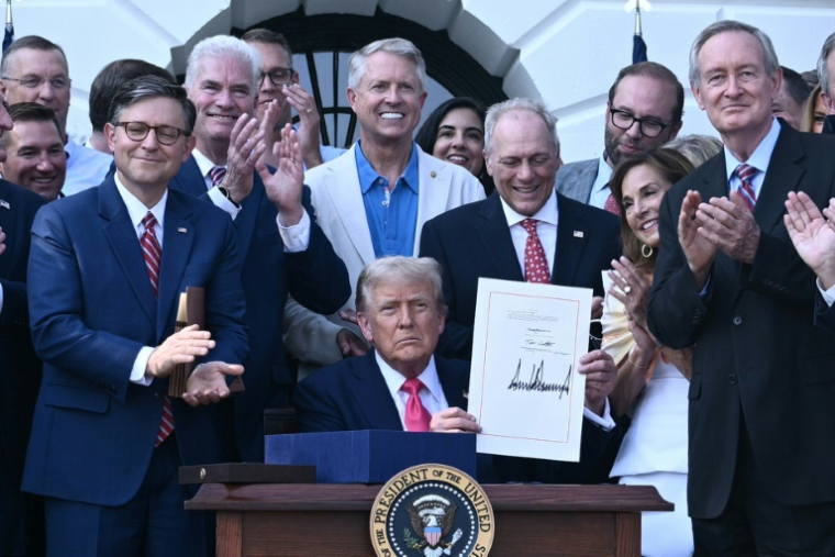 Le président américain Donald Trump montre sa signature sur sa "grande et belle loi" budgétaire à la Maison-Blanche à Washington le 4 juillet 2025 ( POOL / Brendan SMIALOWSKI )