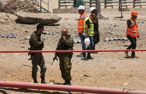 Des membres des forces de sécurité israéliennes sur un site frappé par un tir iranien à Ashdod, dans le sud d'Israël, le 23 juin 2025 ( AFP / GIL COHEN-MAGEN )