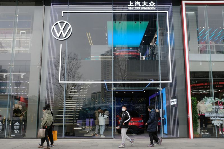 Des personnes passent devant une salle d'exposition de SAIC Volkswagen à Chengdu