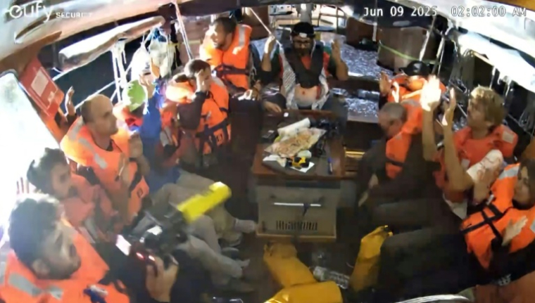 Image tirée d'une vidéo publiée par la Coalition de la flottille pour la liberté, le 9 juin 2025, montrant des militants à bord du bateau Madleen à destination de Gaza, les mains en l'air, alors qu'ils sont interceptés par les forces israéliennes dans les eaux internationales avant d'atteindre le territoire palestinien ( la Coalition de la flottille pour la liberté / - )