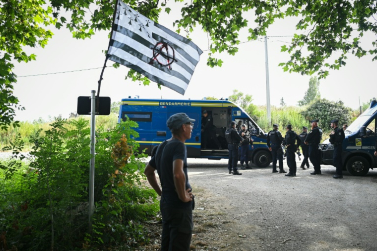 Des gendarmes et des opposants au projet de l'autoroute A69 Toulouse-Castres près de l'entrée du camp où doit se tenir un rassemblement près de Maurens-Scopont, dans le Tarn, le 5 juillet 2025 ( AFP / Matthieu RONDEL )