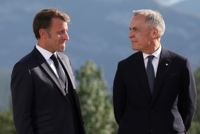 Le président français Emmanuel Macron (g) et le Premier ministre canadien Mark Carney participent à une photo de groupe lors du sommet du G7 à Kananaskis, au Canada, le 16 juin 2025 ( GETTY IMAGES NORTH AMERICA / POOL )
