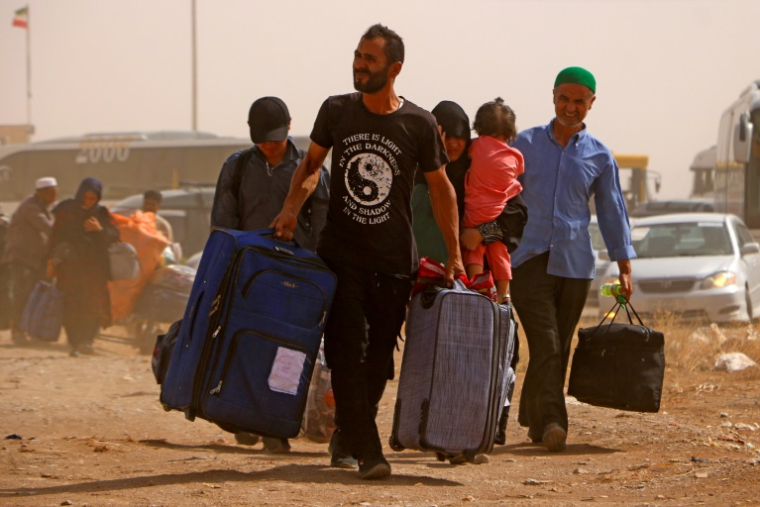 Des réfugiés afghans arrivent d'Iran au poste-frontière d'Islam Qala entre l'Afghanistan et l'Iran le 5 juillet 2025 ( AFP / Mohsen KARIMI )