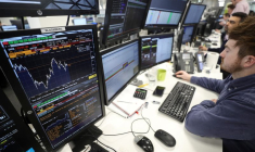 Des traders examinent des informations financières sur des écrans d'ordinateur sur le parquet de négociation d'IG Index à Londres