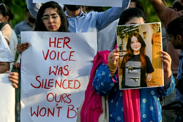 Deux jeunes femmes rendant hommage à l'influenceuse pakistanaise Sana Yousaf, assassinée à son domicile par un individu dont elle avait refusé les avances, lors d'un rassemblement à Islamabad, le 5 juin 2025 ( AFP / Farooq NAEEM )