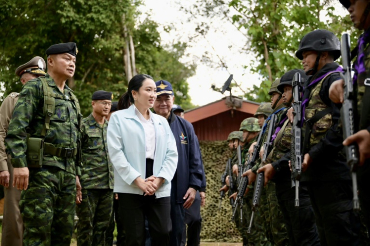 La Première ministre thaïlandaise Paetongtarn Shinawatra passe en revue les troupes dans la base militaire de Morakot, près de la frontière cambodgienne, en compagnie du général Boonsin Padklang (à gauche) le 20 juin 2025 ( ROYAL THAI GOVERNMENT / Handout )