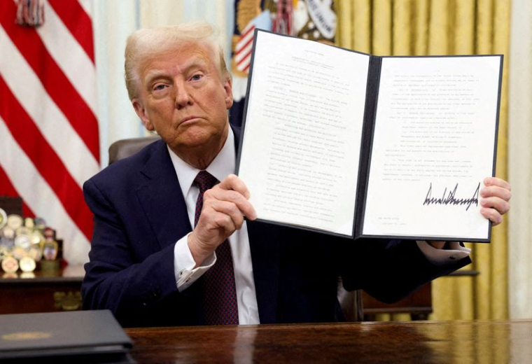 Le président des États-Unis Donald Trump tient un décret signé sur les cryptomonnaies, dans le Bureau ovale de la Maison Blanche, à Washington