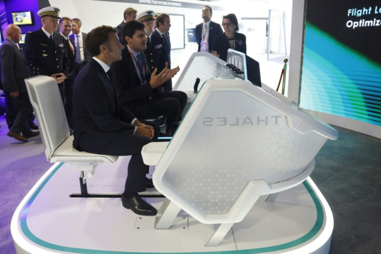 Le président Emmanuel Macron (d) visite le pavillon du géant de la haute technologie au salon du Bourget, près de Paris, le 20 juin 2025 ( POOL / Mohammed BADRA )