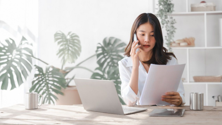 Une femme en train de passer un appel téléphonique pour la gestion de son épargne (Crédits: Adobe Stock)