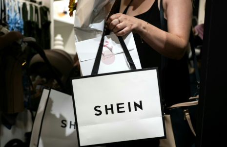 Une cliente porte des sacs après avoir fait des achats dans une boutique éphémère de la marque asiatique Shein, le 26 juin 2025 à Diajon, en Côte-d'Or ( AFP / ARNAUD FINISTRE )