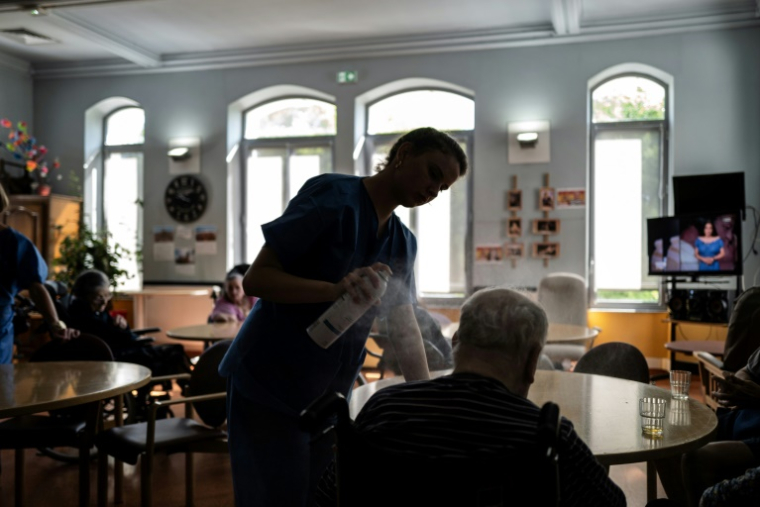 Une infirmière rafraîchit des personnes âgées dans un hôpital gériatrique, à Lyon, le 1er juillet 2025 ( AFP / JEFF PACHOUD )