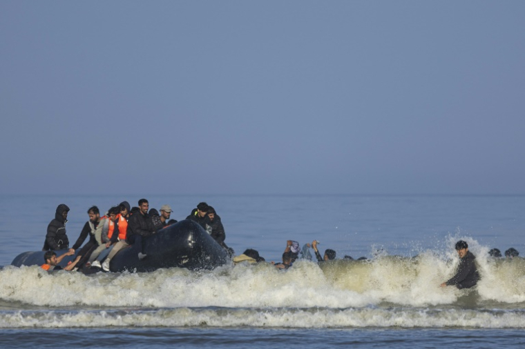 Des migrants tentent de monter dans une embarcation à destination de l'Angleterre, le 30 juin 2025 à Equihen (Pas-de-Calais) ( AFP / Sameer Al-DOUMY )