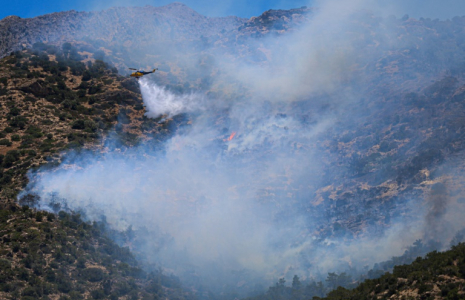 Un hélicoptère largue de l’eau sur un incendie de forêt qui s’est déclaré à Ierapetra, sur l’île grecque de Crète, le 3 juillet 2025 ( AFP / Costas METAXAKIS )