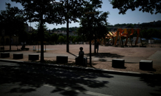 Une personne est assise à l'ombre d'arbres à Lyon, le 25 juin 2025 ( AFP / JEFF PACHOUD )