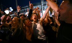 Les fans du groupe de rock britannique Oasis se réjouissent à l'extérieur du Principality Stadium à Cardiff le 4 juillet 2025 ( AFP / Oli SCARFF )