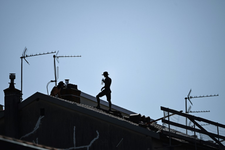 Un homme travaillant sur un toit à Lyon, le 30 juin 2025 ( AFP / OLIVIER CHASSIGNOLE )