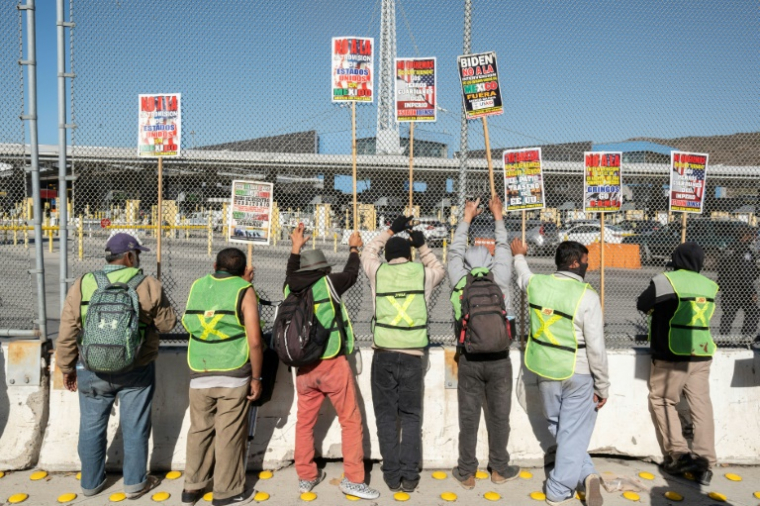 Des migrants et des manifestants au poste frontalier de San Ysidro, à la frontière entre les États-Unis et le Mexique, à Tijuana, au Mexique, le 18 décembre 2024 ( AFP / GUILLERMO ARIAS )