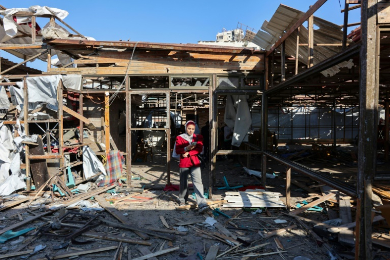 Une Palestinienne marche au milieu des dégâts au café Al-Baqa, dévasté par une frappe israélienne sur le front de mer, à Gaza-ville le 30 juin 2025 ( AFP / Omar AL-QATTAA )
