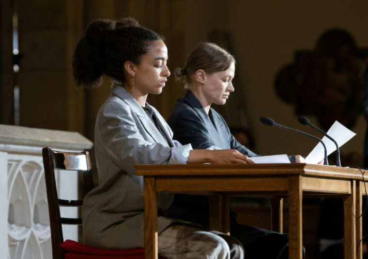 Les actrices allemandes Safira Robens (g) et Mavie Hoerbiger lisent pendant la représentation théâtrale de "Le Procès Pelicot, hommage à Gisele Pelicot" à l'église Sainte-Elizabeth à Vienne, en Autriche, le 18 juin 2025 ( AFP / Joe Klamar )
