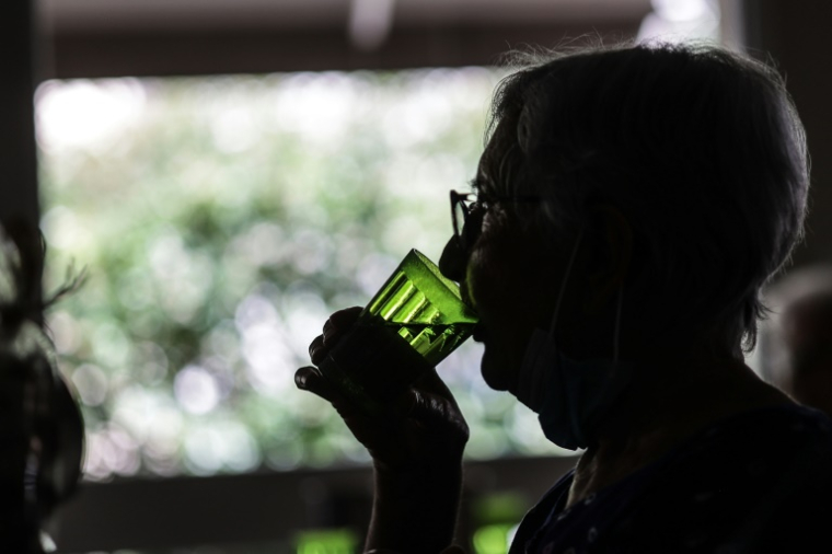Une femme boit un verre d'eau, dans une résidence sénior de Bordeaux, le 16 juin 2022 lors d'une vague de chaleur ( AFP / Thibaud MORITZ )