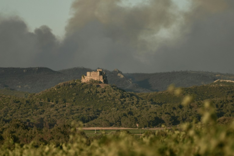 De la fumée s'élève derrière le château de Saint-Martin-de-Toques, près de Narbonne le 7 juillet 2025 ( AFP / IDRISS BIGOU-GILLES )