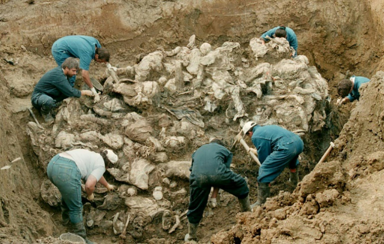 Des experts internationaux exhument les corps de victimes présumées du massacre de Srebrenica, le 24 juillet 1996 dans le village de Pilica, à 300 km au nord-est de Sarajevo ( AFP / Odd ANDERSEN )