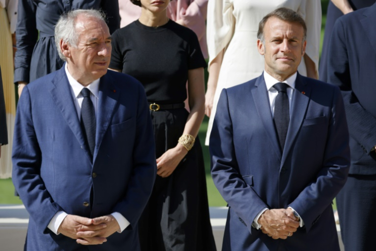 Le Premier ministre français François Bayrou (G) et le président français Emmanuel Macron (D) posent pour une photo de famille avec les membres du gouvernement avant la réunion hebdomadaire du cabinet au palais de l'Élysée à Paris, le 2 juillet 2025 ( AFP / Ludovic MARIN )
