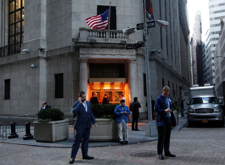 Des traders se tiennent devant la Bourse de New York avant l'ouverture des marchés
