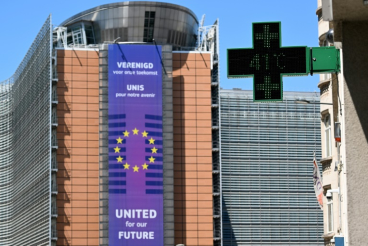 Un thermomètre de pharmacie affiche 41°C, avec en arrière-plan le siège de la Commission européenne, à Bruxelles, le 23 juin 2025 ( AFP / Nicolas TUCAT )