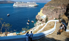Un bateau de croisière près de la ville de Fira, sur l'île grecque de Santorin, le 20 juillet 2024 ( AFP / ARIS OIKONOMOU )