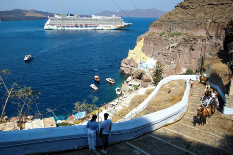 Un bateau de croisière près de la ville de Fira, sur l'île grecque de Santorin, le 20 juillet 2024 ( AFP / ARIS OIKONOMOU )