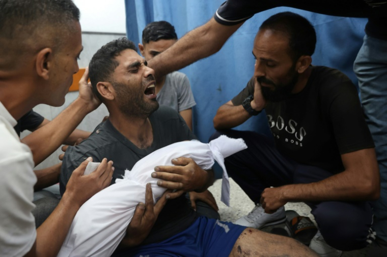 Un Palestinien pleure en portant le corps de son bébé tué dans une frappe israélienne selon la Défense civile, à l'hôpital al-Chifa de la ville de Gaza, le 7 juillet 2025 ( AFP / Omar AL-QATTAA )