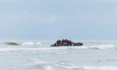 Des migrants se pressent sur le canot pneumatique d'un passeur pour tenter de traverser la Manche, après avoir quitté la plage de l'Ecault à Saint-Etienne-au-Mont, près de Neufchâtel-Hardelot, dans le Pas-de-Calais, le 30 octobre 2024 ( AFP / Sameer Al-DOUMY )