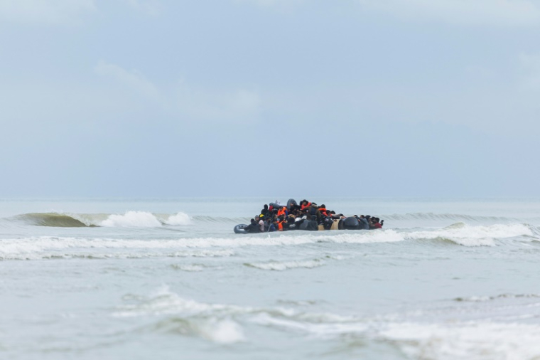 Des migrants se pressent sur le canot pneumatique d'un passeur pour tenter de traverser la Manche, après avoir quitté la plage de l'Ecault à Saint-Etienne-au-Mont, près de Neufchâtel-Hardelot, dans le Pas-de-Calais, le 30 octobre 2024 ( AFP / Sameer Al-DOUMY )